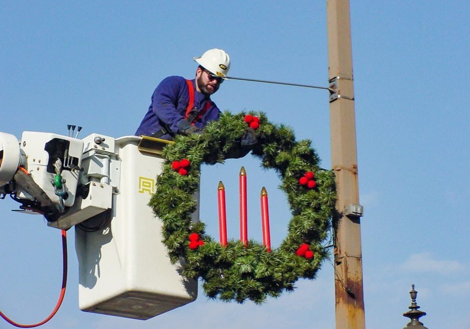 HEC Harrisonburg Electric Commission employee hanging wreath on utility pole